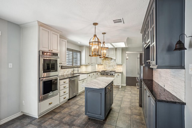 kitchen with a kitchen island, decorative light fixtures, sink, backsplash, and stainless steel appliances