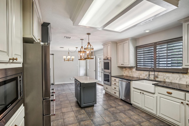 kitchen featuring pendant lighting, tasteful backsplash, sink, a center island, and stainless steel appliances