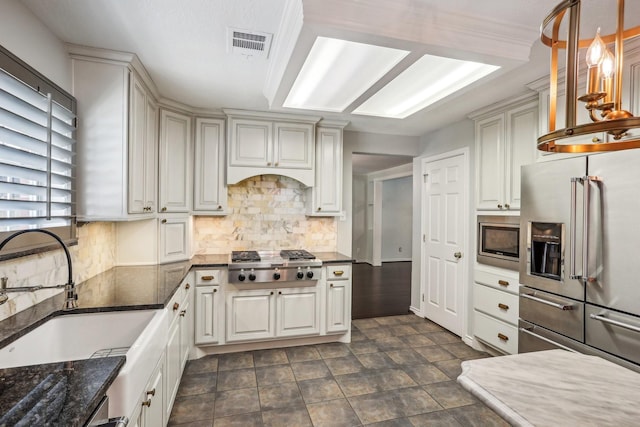 kitchen featuring decorative light fixtures, sink, white cabinets, decorative backsplash, and stainless steel appliances