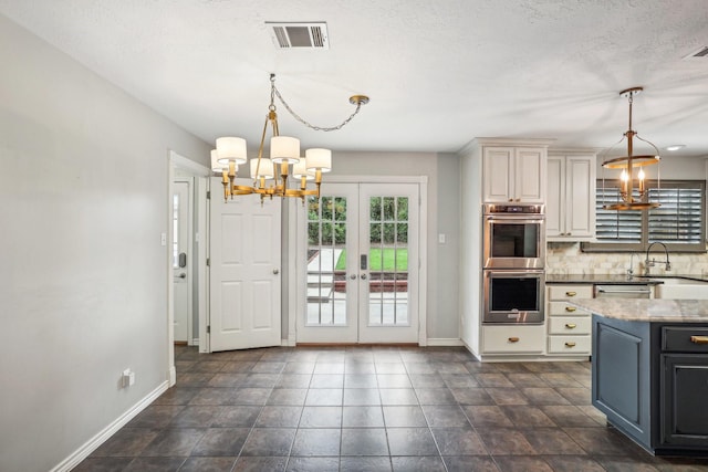 kitchen featuring sink, an inviting chandelier, hanging light fixtures, backsplash, and stainless steel appliances