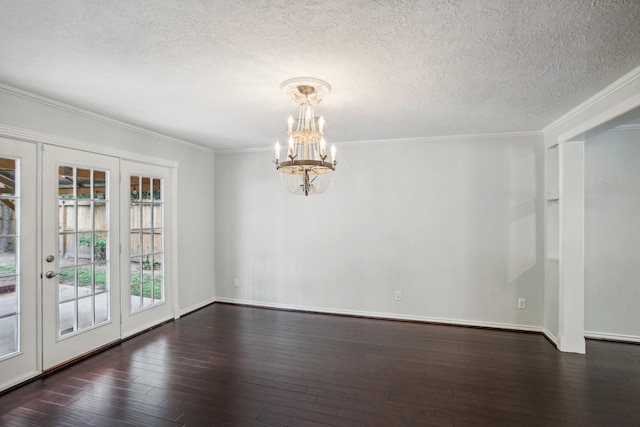 spare room with crown molding, dark wood-type flooring, a textured ceiling, and a chandelier