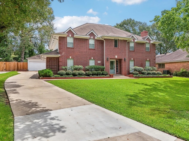 colonial inspired home with a garage, central AC unit, and a front yard