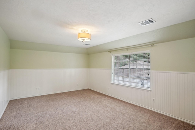 carpeted spare room featuring a textured ceiling