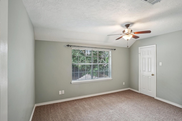 carpeted spare room featuring vaulted ceiling, a textured ceiling, and ceiling fan