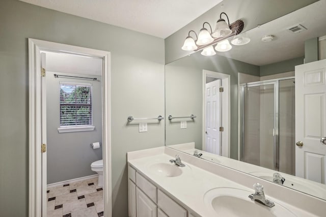 bathroom featuring vanity, toilet, and an enclosed shower