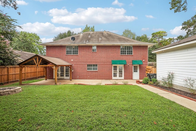 back of house featuring a lawn, a patio area, and french doors