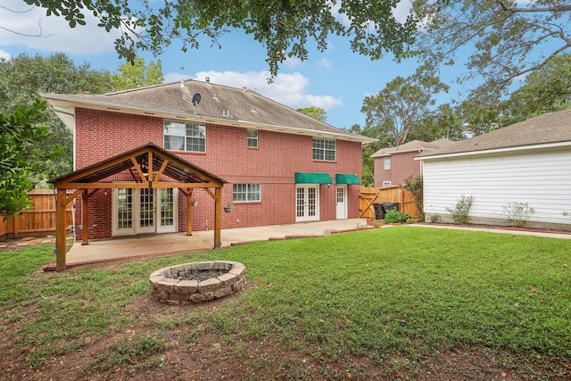 back of property featuring a patio area, a lawn, french doors, and an outdoor fire pit