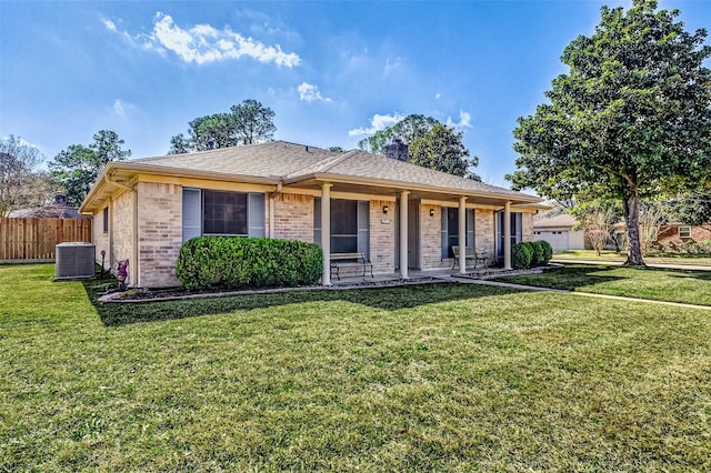 ranch-style house with a front yard and central AC unit