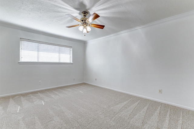 carpeted empty room with crown molding, ceiling fan, and a textured ceiling