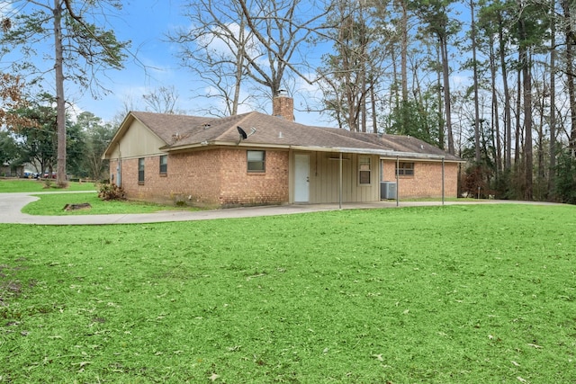 rear view of house with cooling unit, a yard, and a patio area