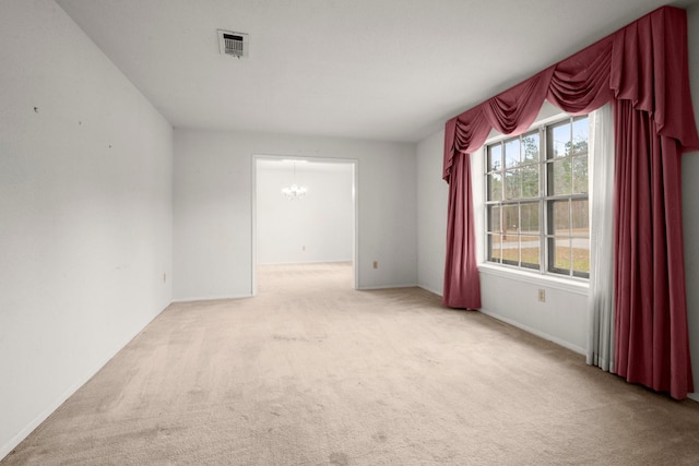 unfurnished room with light carpet and a notable chandelier