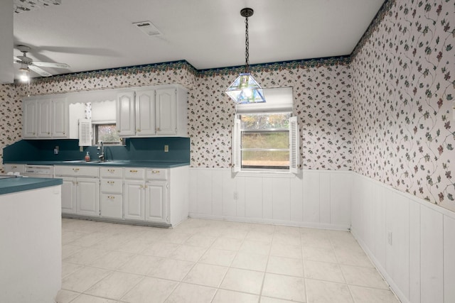 kitchen featuring white cabinetry, a healthy amount of sunlight, sink, and decorative light fixtures