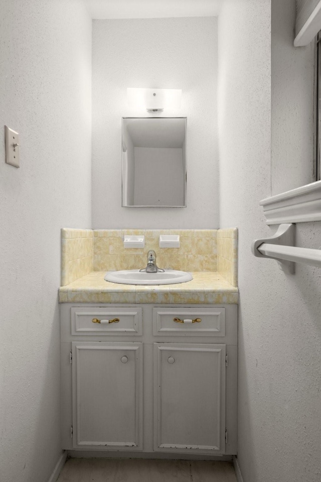 bathroom featuring vanity and decorative backsplash