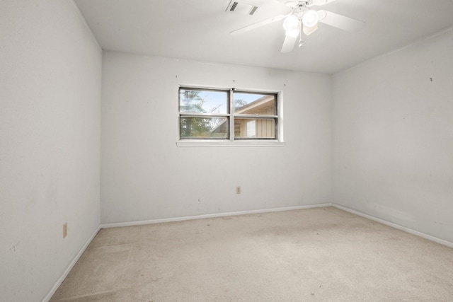 spare room featuring light colored carpet and ceiling fan