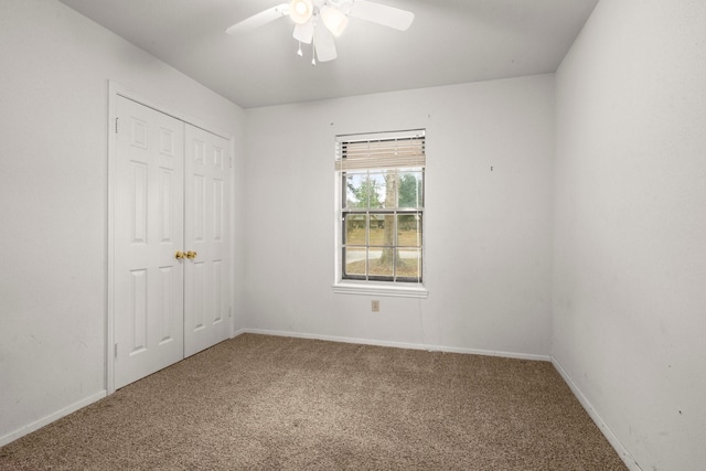 unfurnished bedroom with ceiling fan, carpet flooring, and a closet