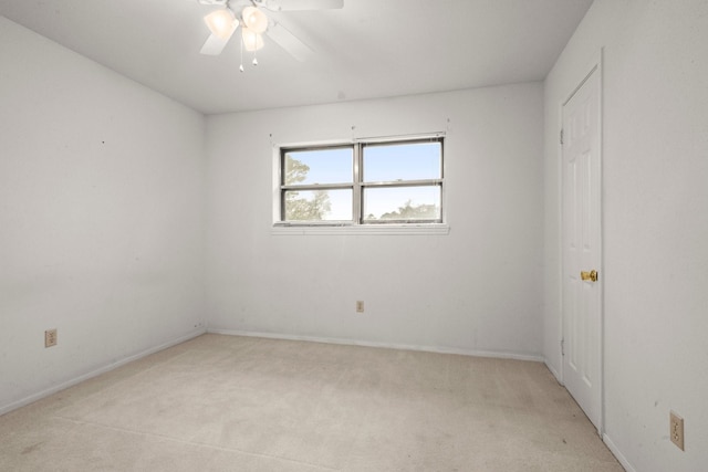 spare room featuring light colored carpet and ceiling fan