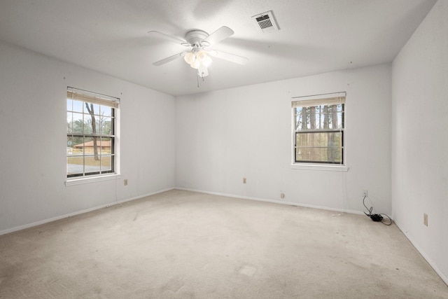 unfurnished room featuring plenty of natural light, light colored carpet, and ceiling fan