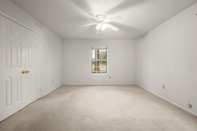 empty room with light colored carpet and ceiling fan