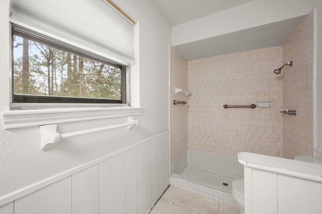 bathroom with toilet and tiled shower