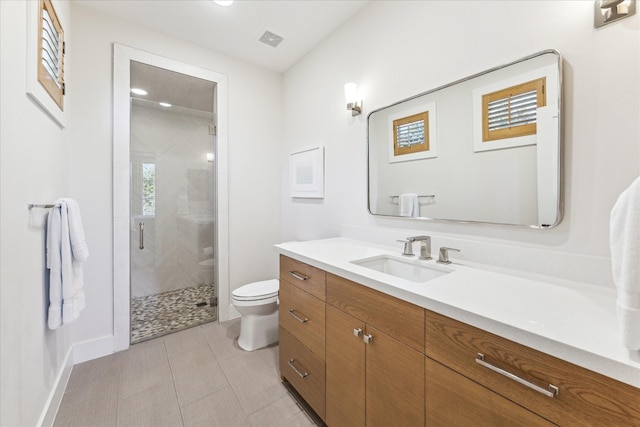 bathroom featuring vanity, toilet, a shower with shower door, and tile patterned flooring