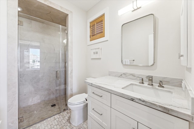 bathroom with vanity, toilet, and a shower with door