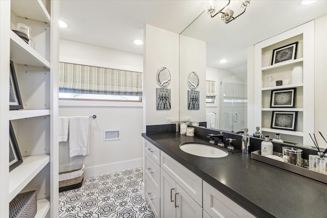 bathroom featuring a shower with door and vanity