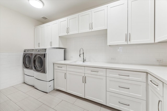 washroom with sink, cabinets, and independent washer and dryer