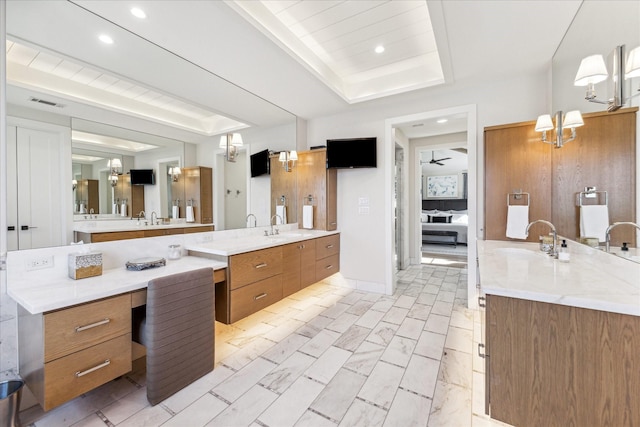 bathroom with vanity, a raised ceiling, and ceiling fan