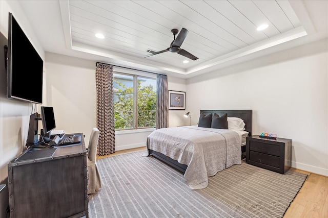 bedroom featuring hardwood / wood-style flooring, wooden ceiling, ceiling fan, and a tray ceiling