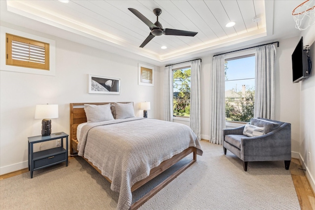 bedroom with a raised ceiling, ceiling fan, wood ceiling, and light hardwood / wood-style flooring