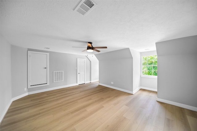 bonus room featuring ceiling fan, a textured ceiling, and light wood-type flooring