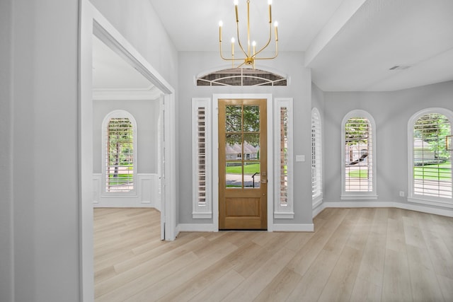 entrance foyer with light hardwood / wood-style flooring and a notable chandelier