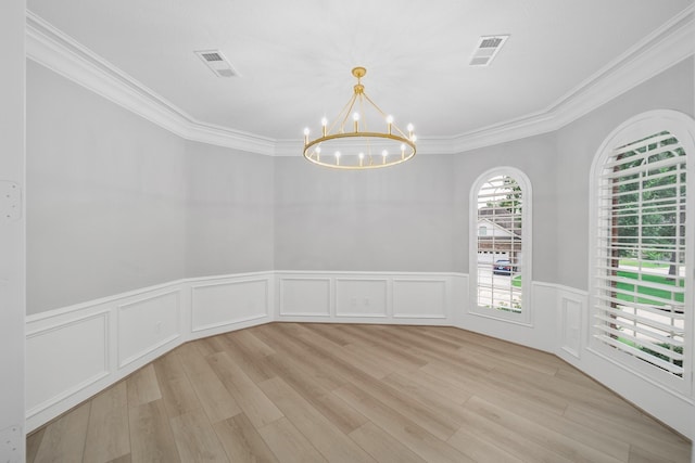 spare room with ornamental molding, light hardwood / wood-style floors, and a chandelier