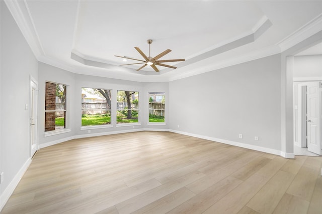 spare room featuring crown molding, ceiling fan, light hardwood / wood-style floors, and a tray ceiling