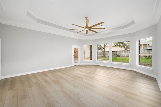 unfurnished room with crown molding, ceiling fan, a raised ceiling, and light hardwood / wood-style floors