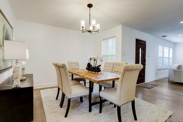 dining room with hardwood / wood-style floors and a chandelier