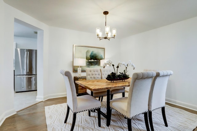 dining room with an inviting chandelier and wood-type flooring