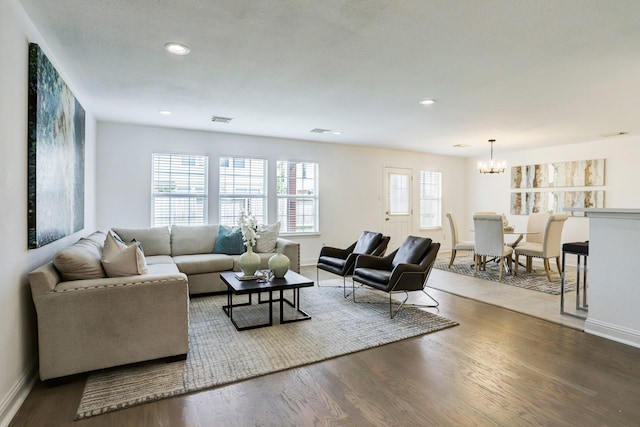 living room with an inviting chandelier and hardwood / wood-style flooring