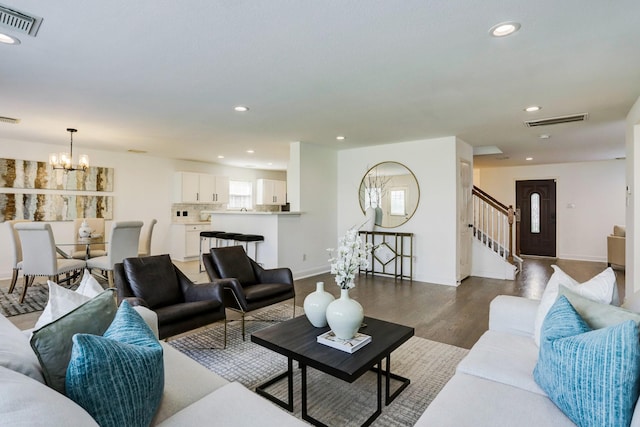 living room with dark wood-type flooring and a chandelier