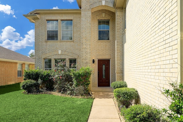 entrance to property featuring a lawn