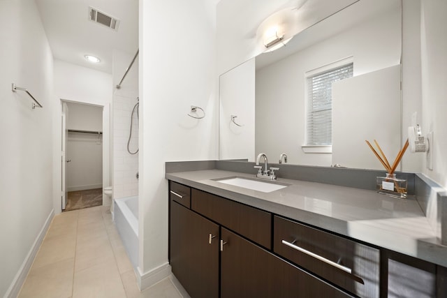 bathroom with tiled shower / bath, vanity, and tile patterned floors