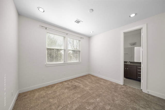 unfurnished room with sink and light carpet