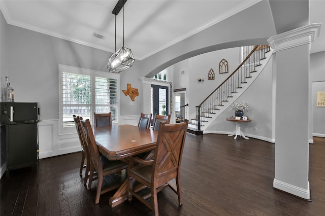 dining area featuring crown molding, dark wood-type flooring, plenty of natural light, and ornate columns