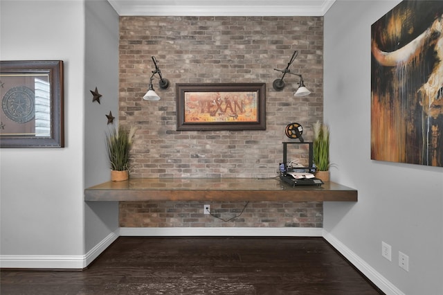 hall featuring ornamental molding, dark hardwood / wood-style floors, and brick wall