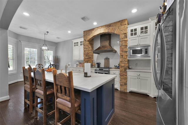 kitchen with white cabinetry, stainless steel appliances, custom range hood, and pendant lighting