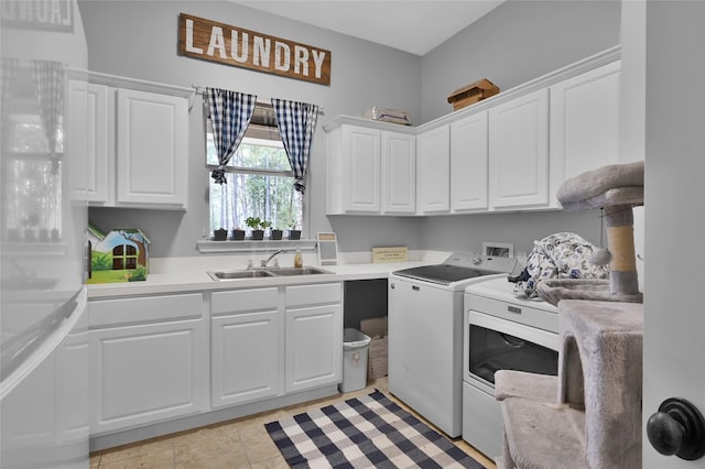 washroom featuring sink, light tile patterned floors, cabinets, and washing machine and clothes dryer