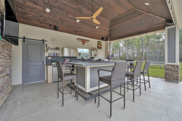 view of patio / terrace with an outdoor wet bar, a trampoline, and ceiling fan