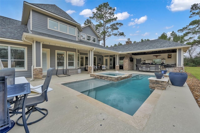 view of pool with a patio area and an in ground hot tub