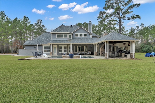 rear view of house with a patio and a lawn