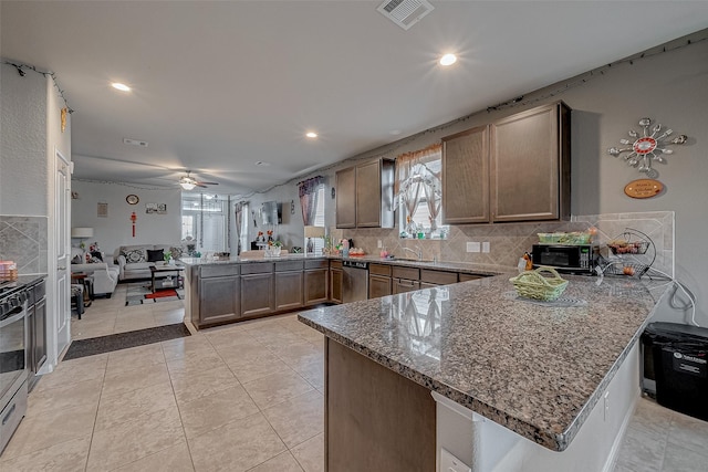 kitchen featuring stone counters, light tile patterned flooring, backsplash, and kitchen peninsula